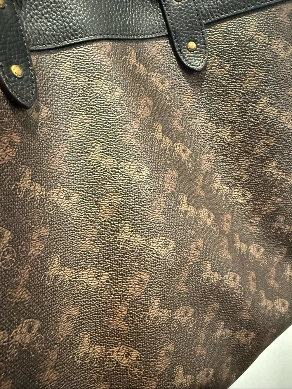 This is a Coach Field Tote in Truffle Black with a horse and carriage print